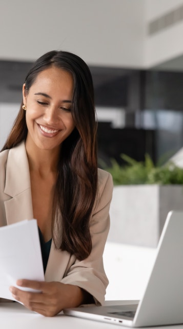 A woman smiling as she reviews a document